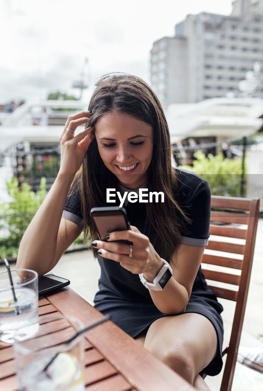 Young beautiful woman using her smartphone on a terrace