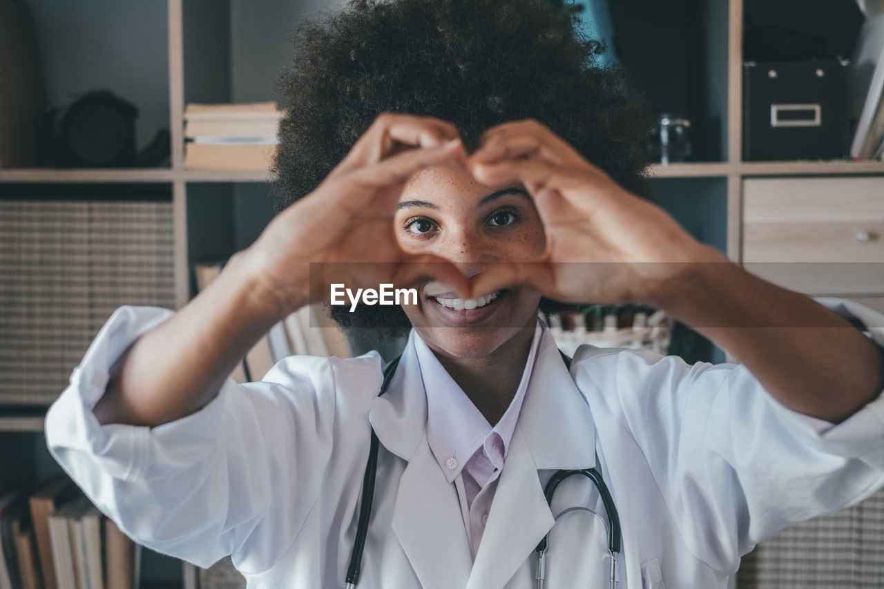 Doctor making heart gesture at clinic