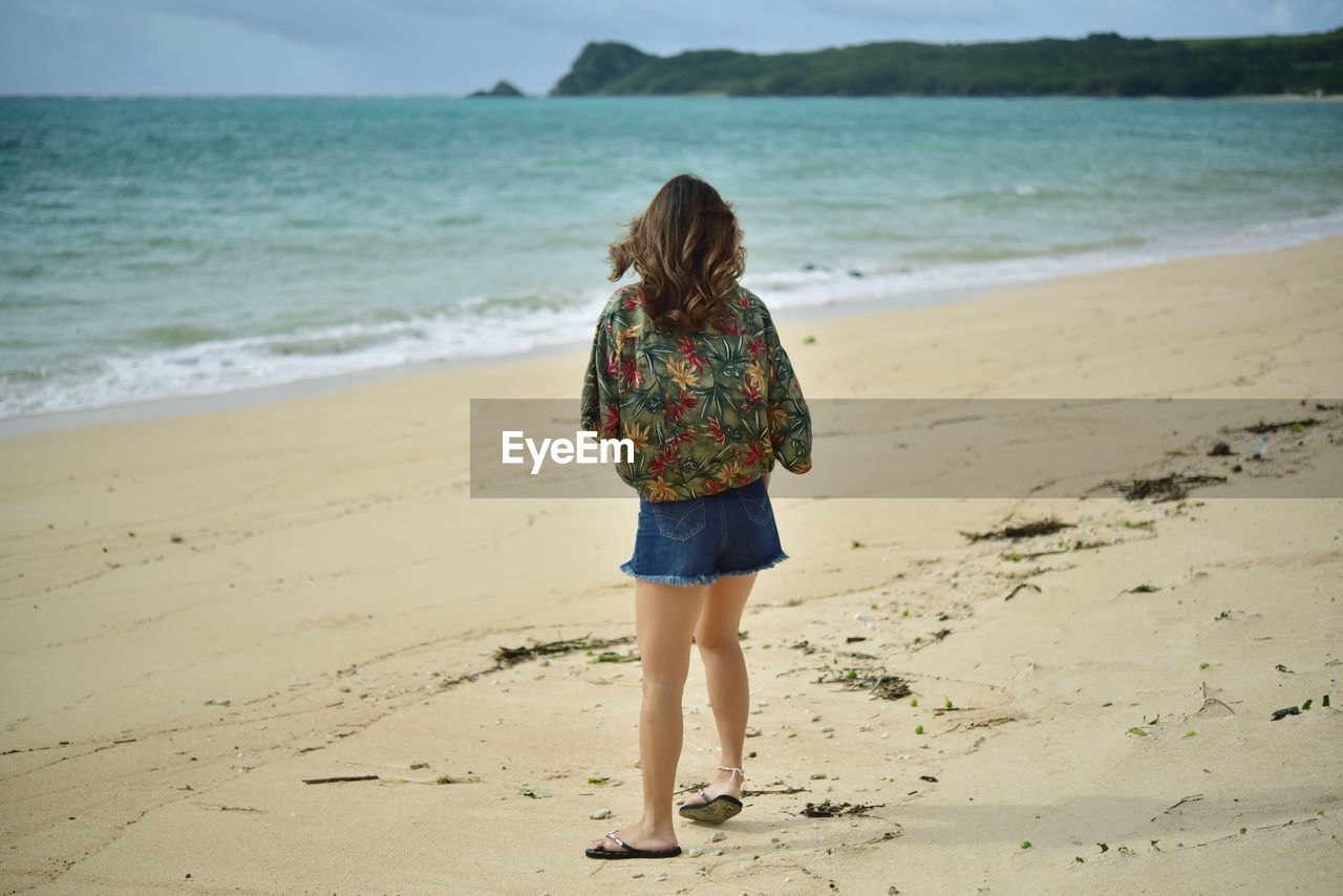 Rear view of woman standing on beach