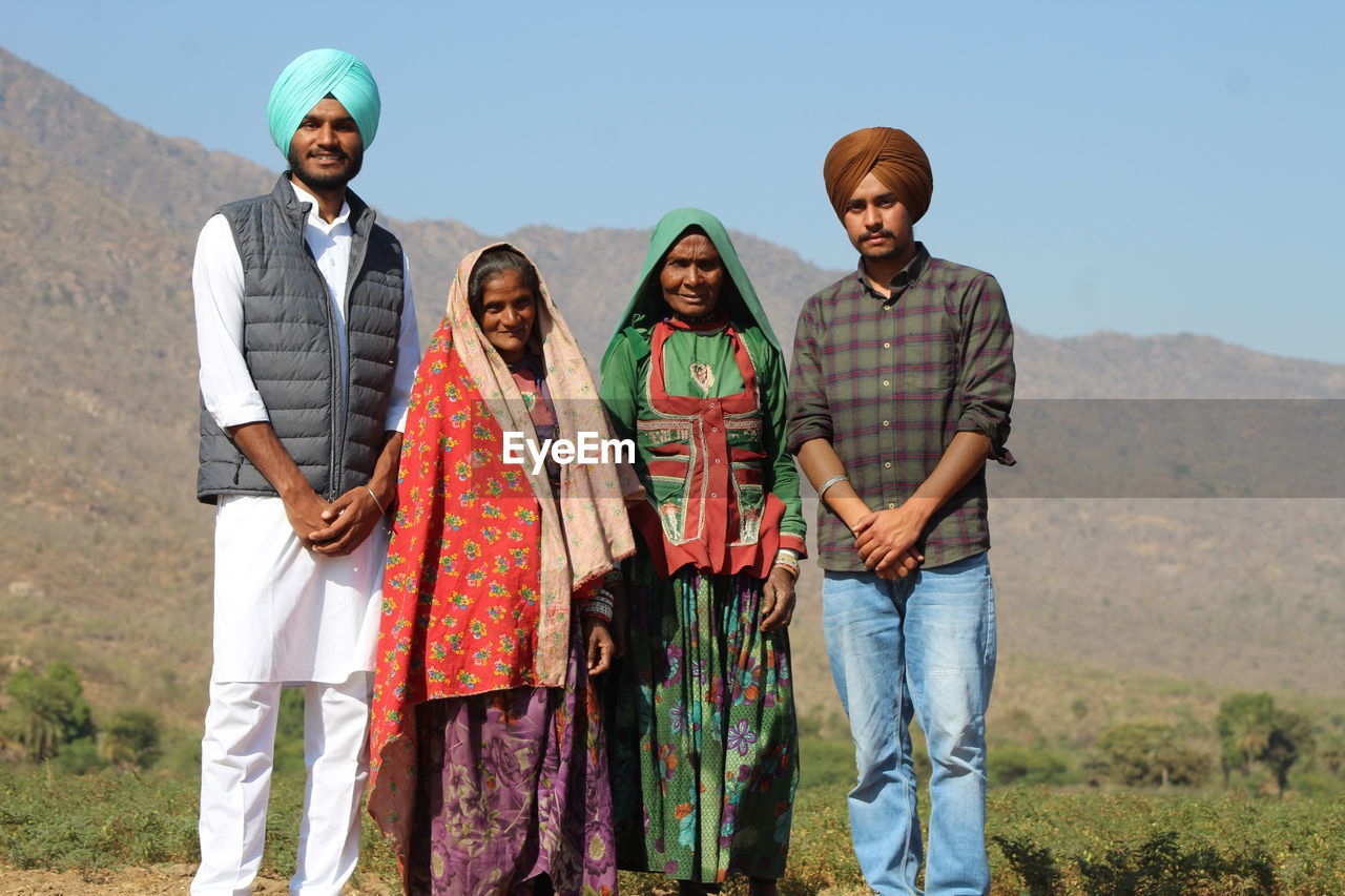 Portrait of smiling peoplestanding outdoors, contrasting classes of economy 