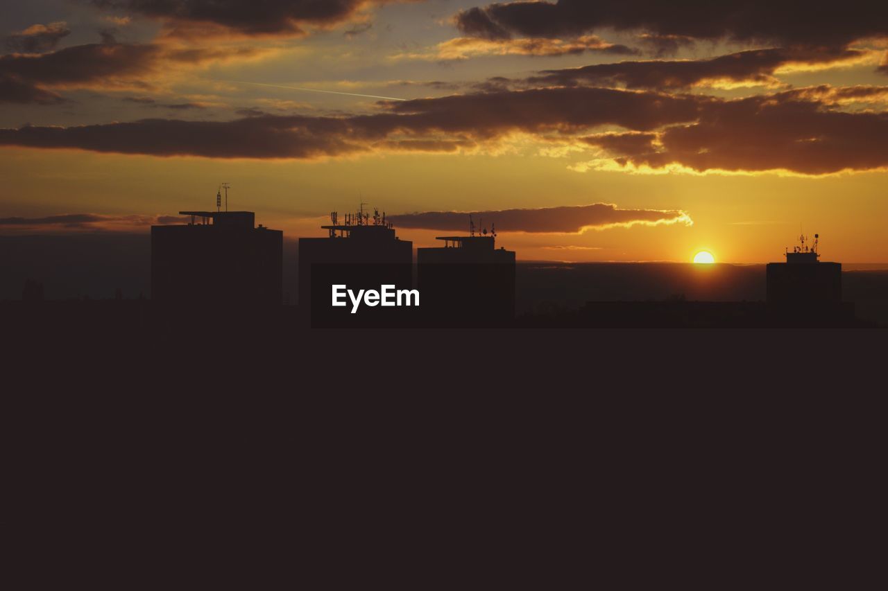 Silhouette buildings against sky during sunset