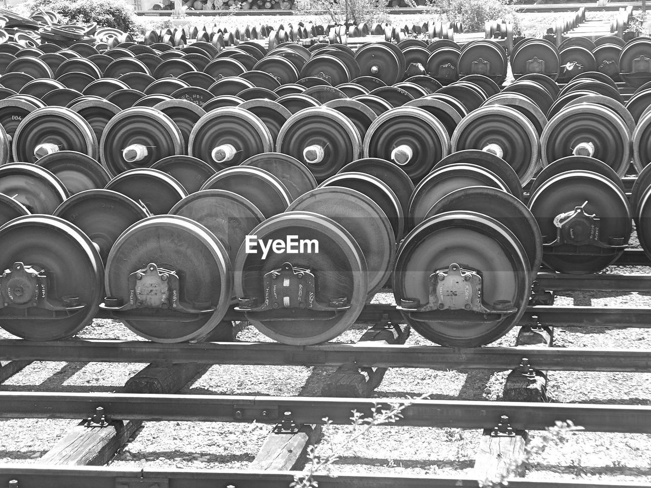 Row of metal structures, train wheels, black and white