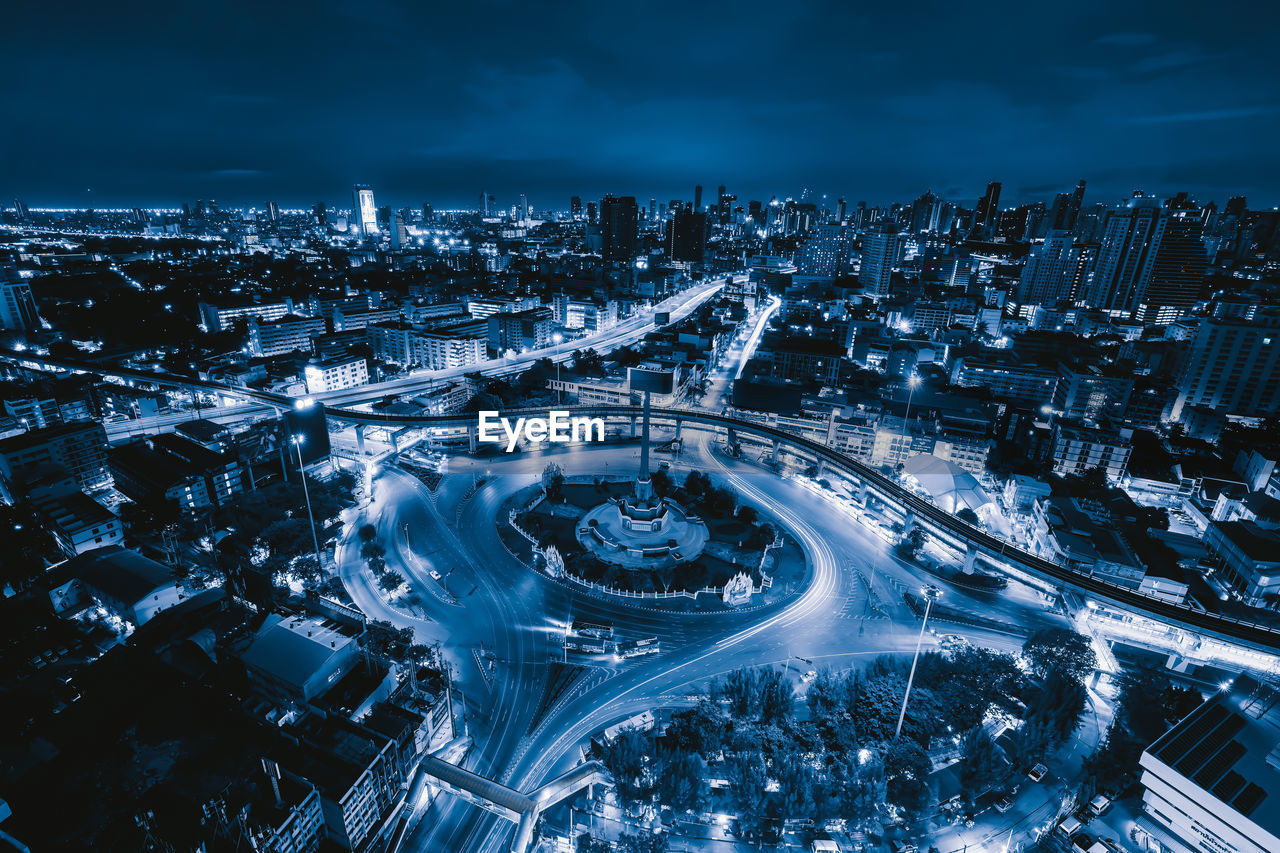 AERIAL VIEW OF ILLUMINATED CITY BUILDINGS AT NIGHT