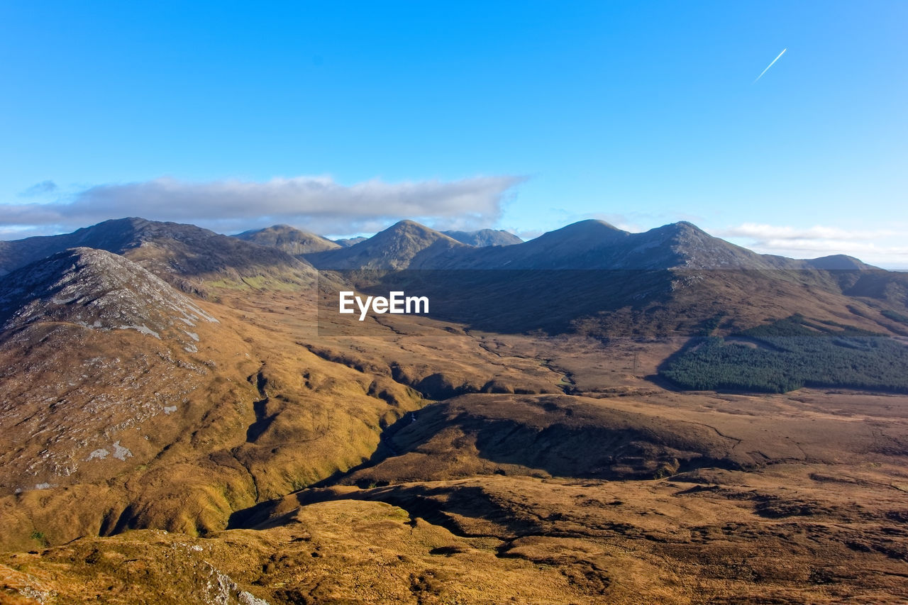 Scenic view of mountains against blue sky