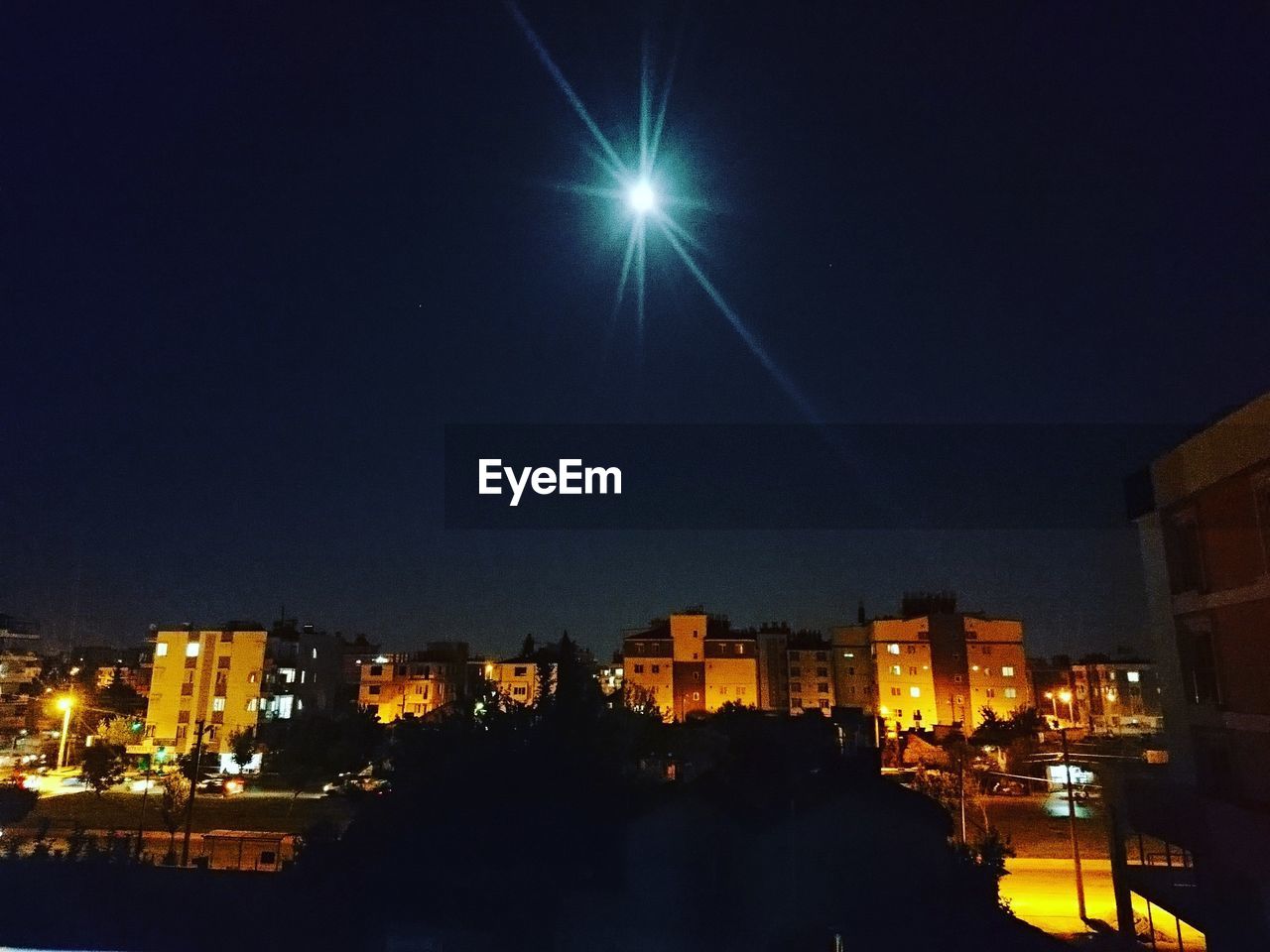 ILLUMINATED CITYSCAPE AGAINST SKY AT NIGHT