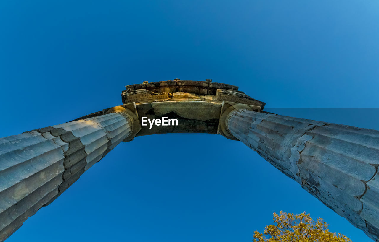 Directly below shot of architectural columns against clear blue sky