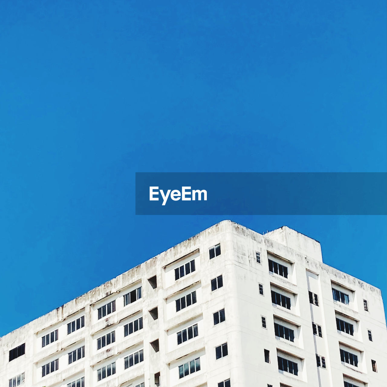 LOW ANGLE VIEW OF BUILDING AGAINST BLUE SKY