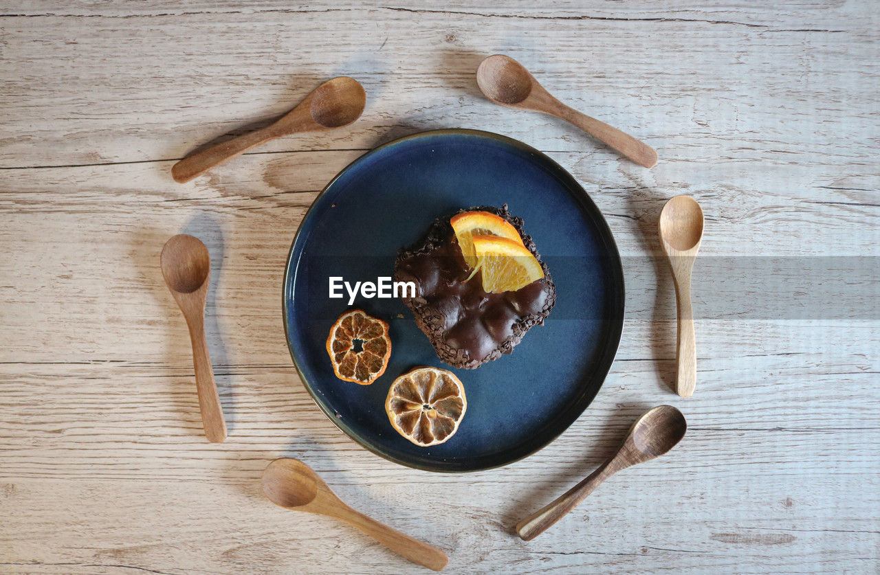food and drink, wood, food, kitchen utensil, healthy eating, freshness, eating utensil, high angle view, directly above, wellbeing, spoon, table, indoors, no people, studio shot, produce, still life, tableware, fruit, nut - food, household equipment, rustic, spice, bowl, nut, ingredient, cutting board, crockery, plate