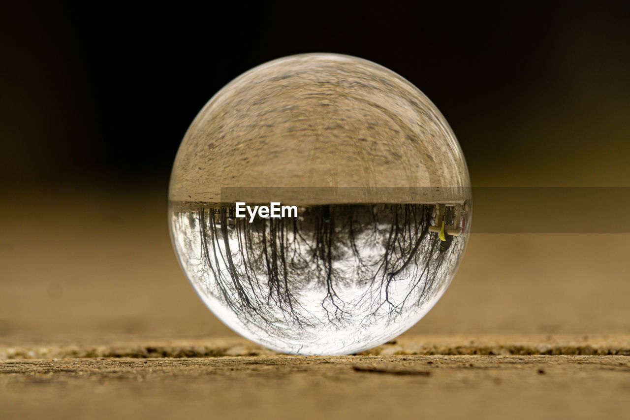 Close-up of crystal ball on land against sky at night