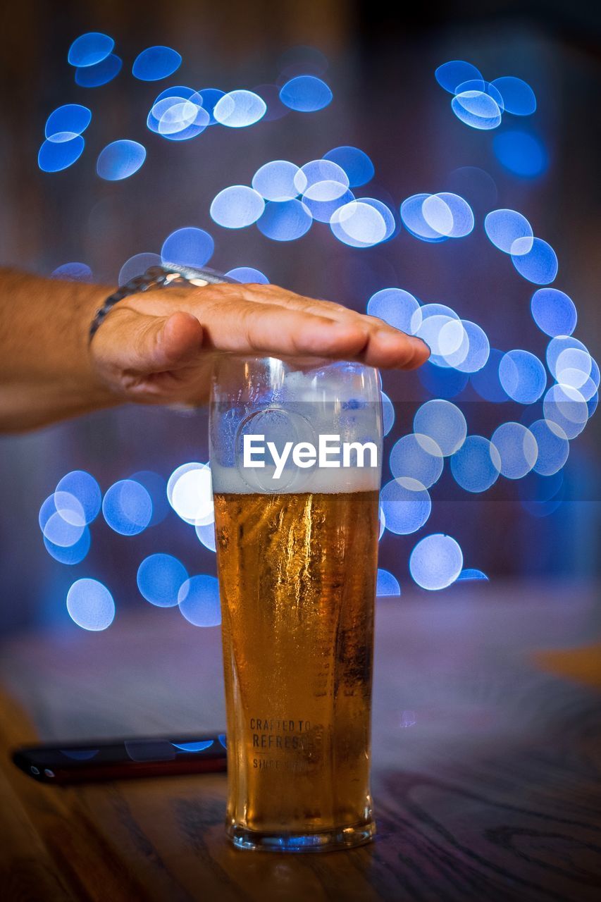 Beer glass with hand and bokeh