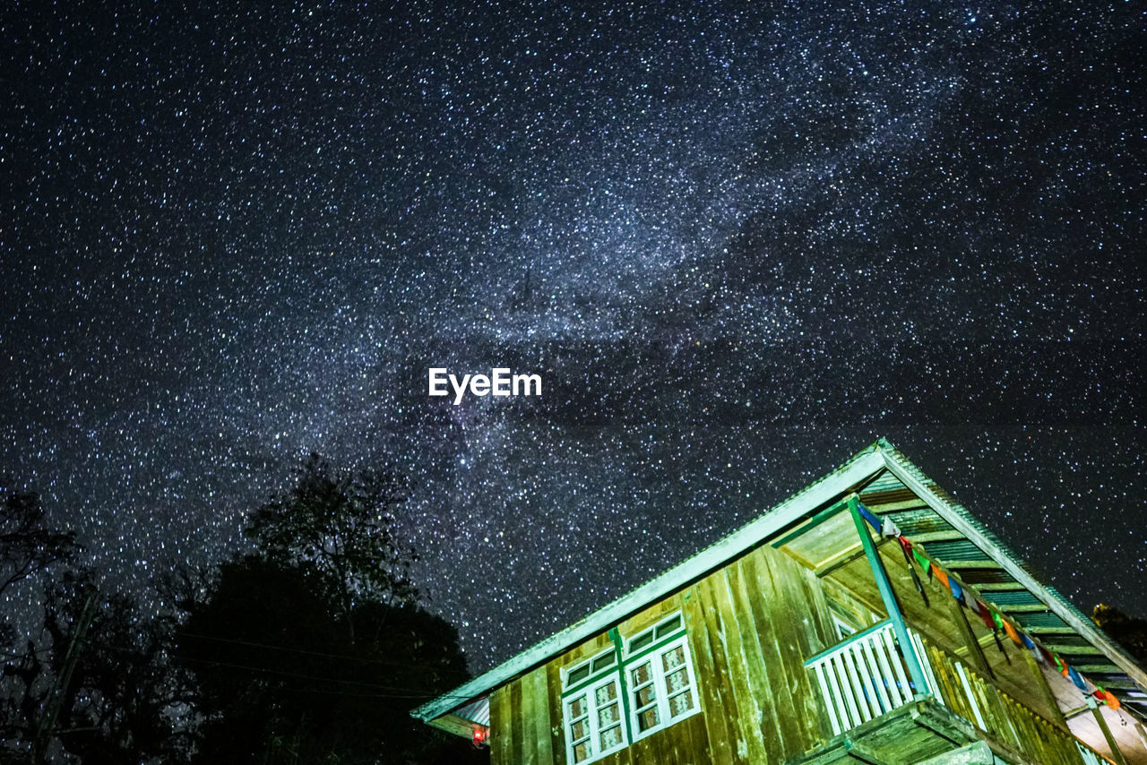 LOW ANGLE VIEW OF ILLUMINATED BUILDING AGAINST SKY