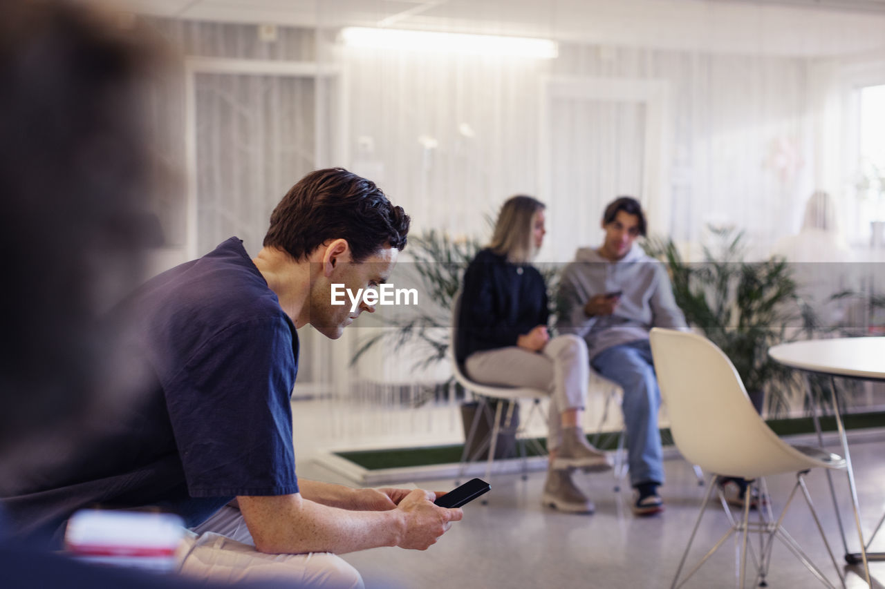 Man using smart phone in waiting room