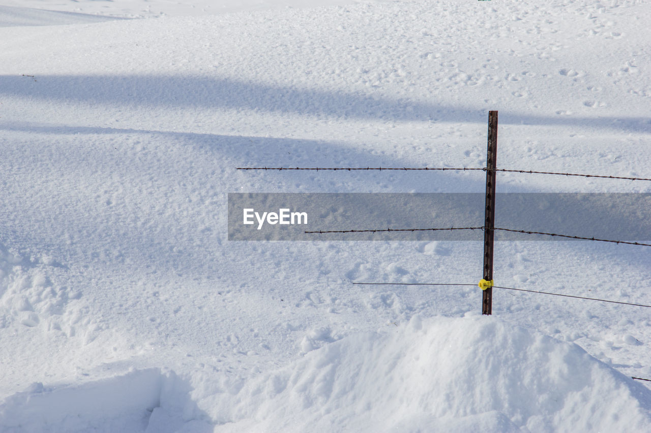 Fence buried in a snow drift.