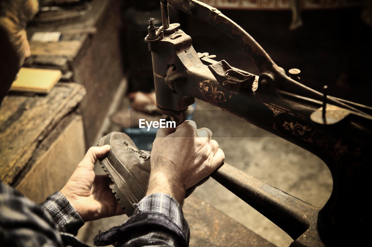 HIGH ANGLE VIEW OF MAN WORKING AT METAL