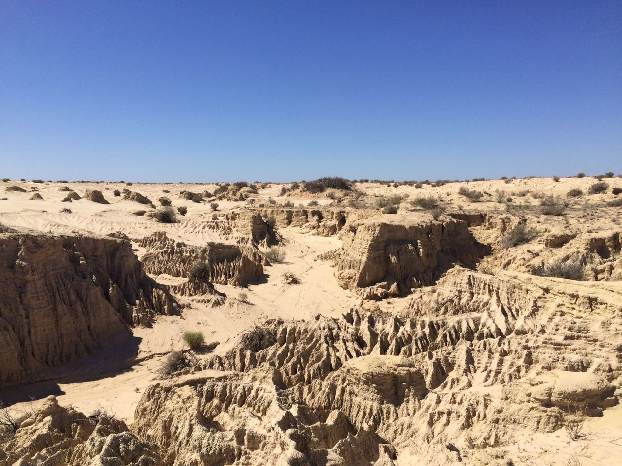 Scenic view of desert against clear blue sky