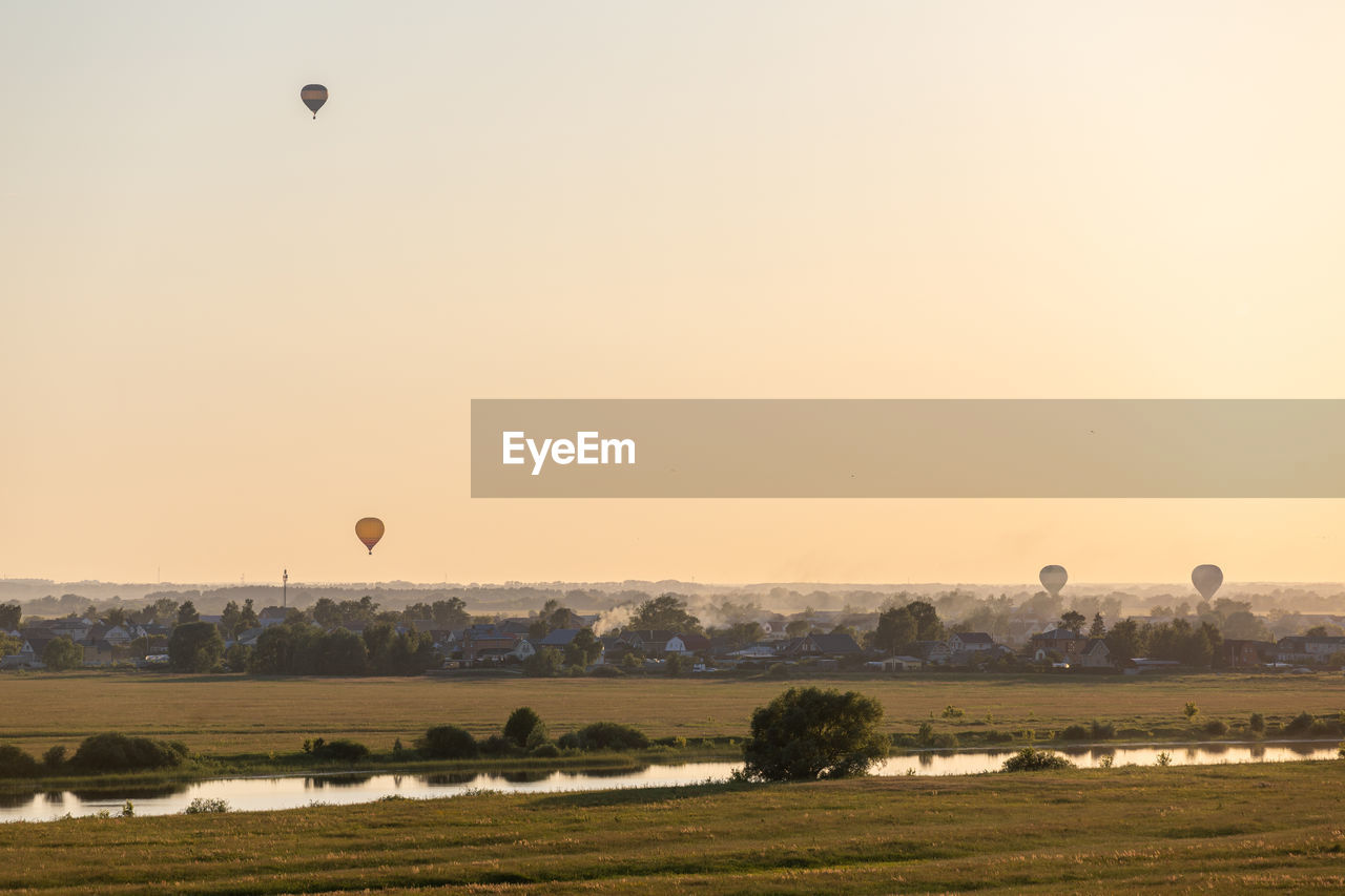 Colorful hot air balloons soar in the sky at dusk or dawn. flight over the fog at sunrise or sunset.