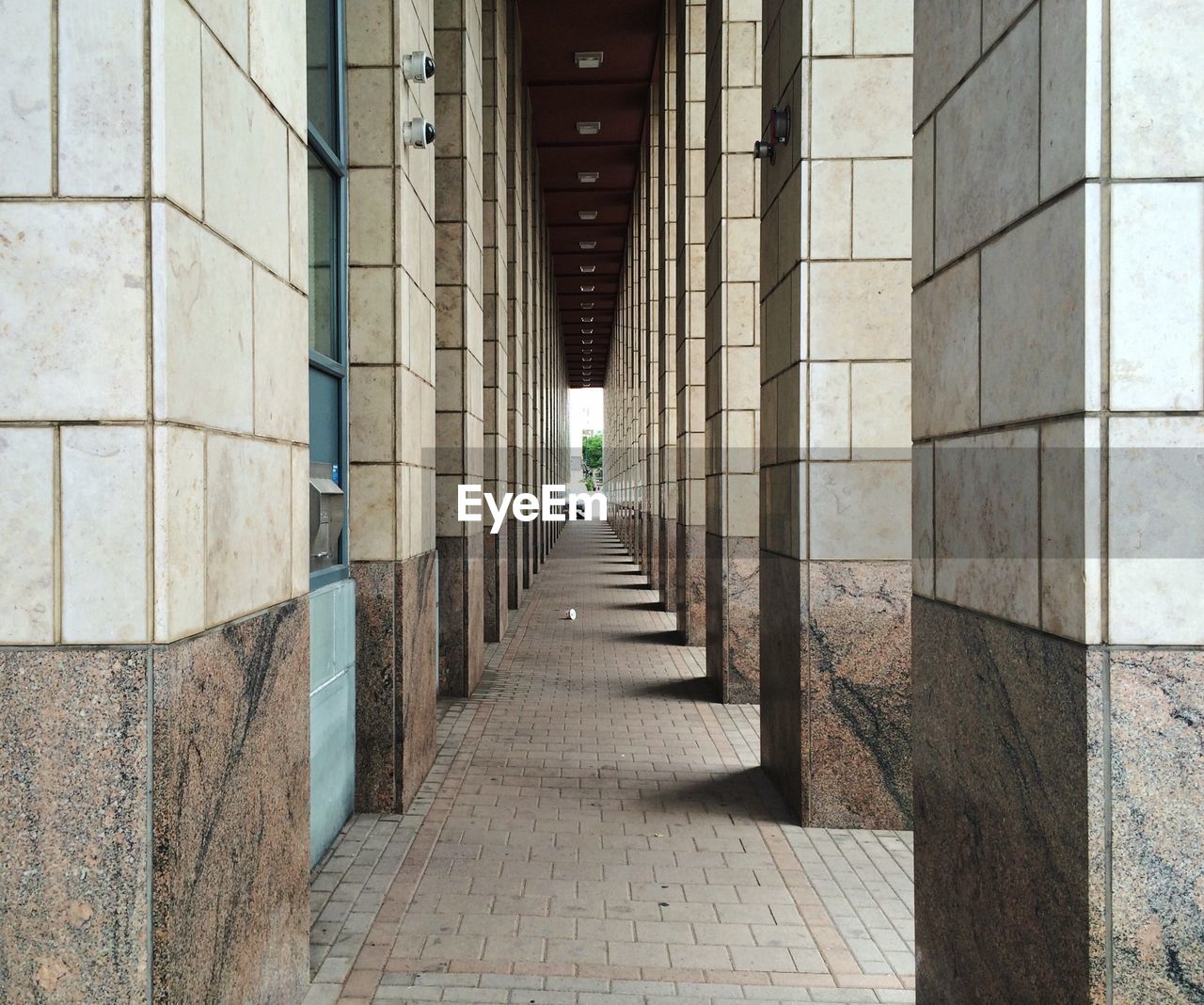 Empty narrow corridor along pillars