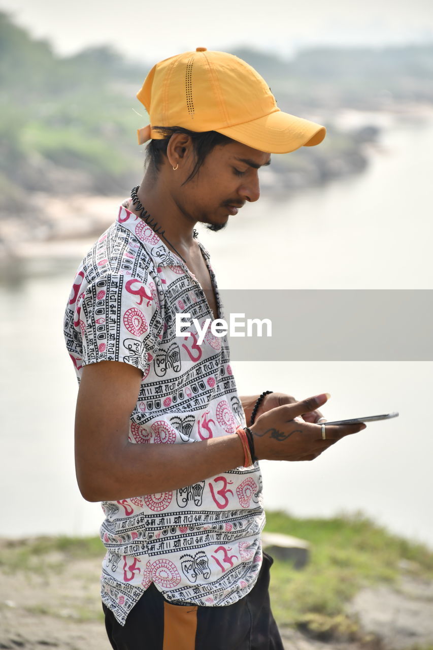 Men model using mobile phone in daylight
