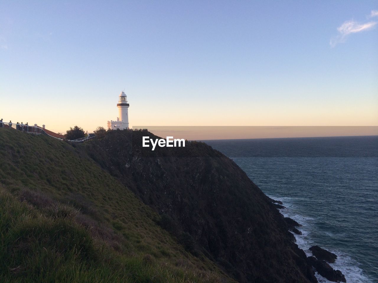 LIGHTHOUSE BY SEA AGAINST SKY DURING SUNSET