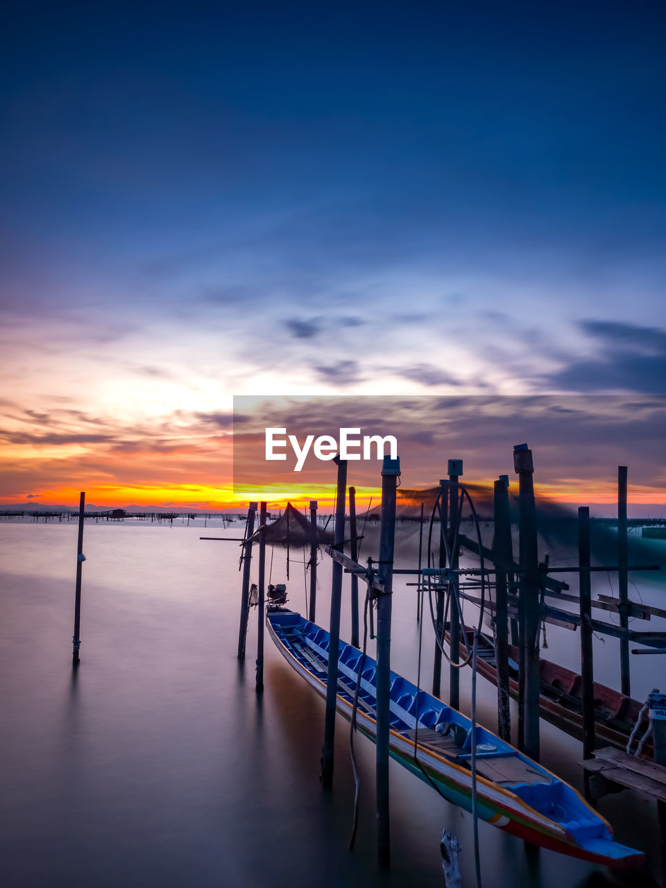 sky, water, reflection, sunset, sea, pier, horizon, ocean, dusk, evening, cloud, nature, dock, beauty in nature, scenics - nature, transportation, tranquility, nautical vessel, tranquil scene, blue, shore, beach, travel destinations, wave, coast, land, travel, architecture, outdoors, sunlight, orange color, mode of transportation, no people, idyllic, horizon over water, jetty, silhouette