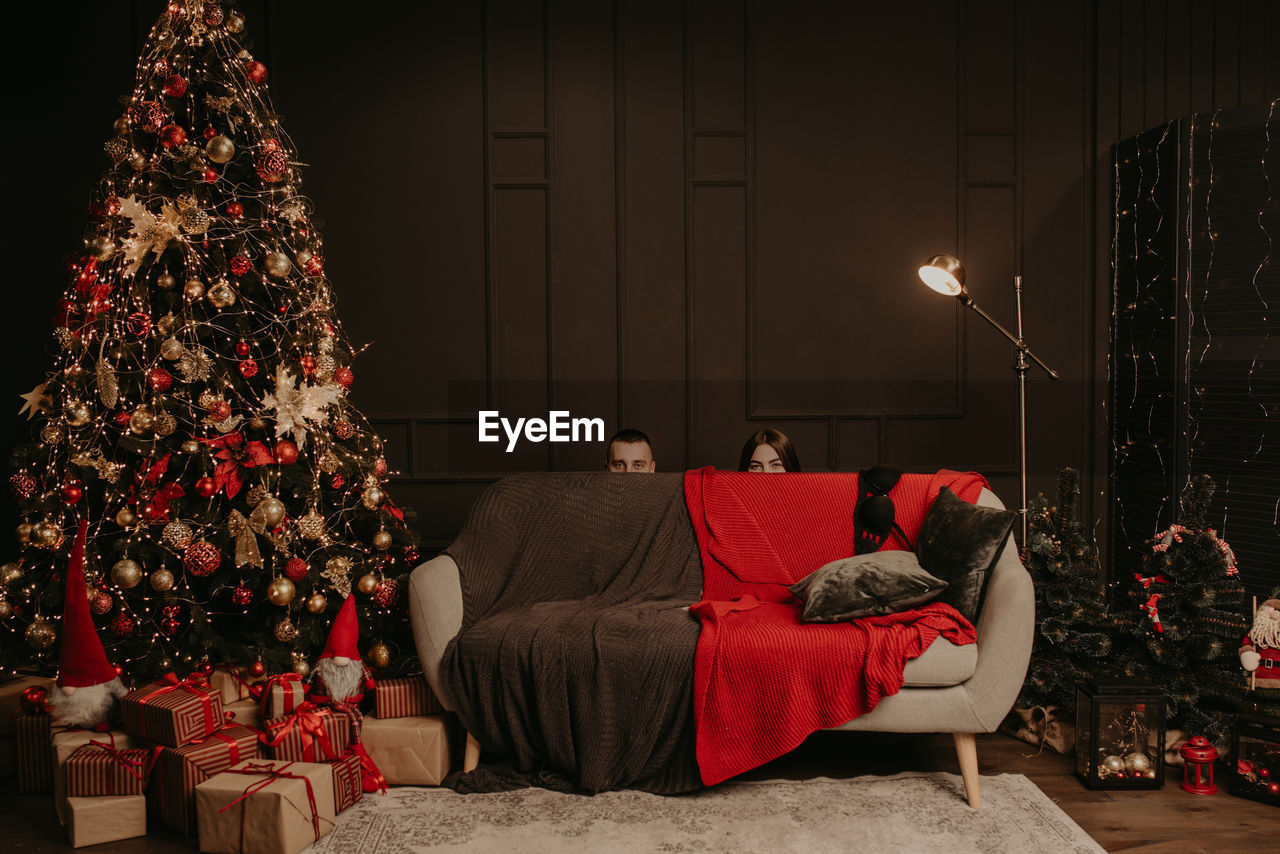 Rear view of woman sitting on sofa at home