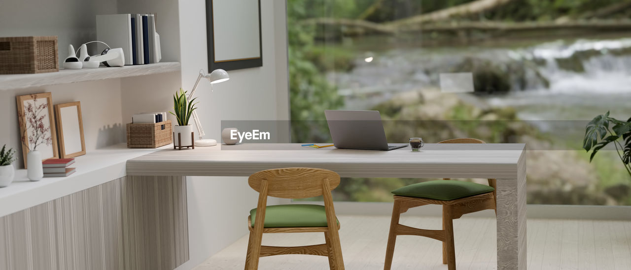 EMPTY CHAIRS AND TABLE AGAINST WALL AT HOME