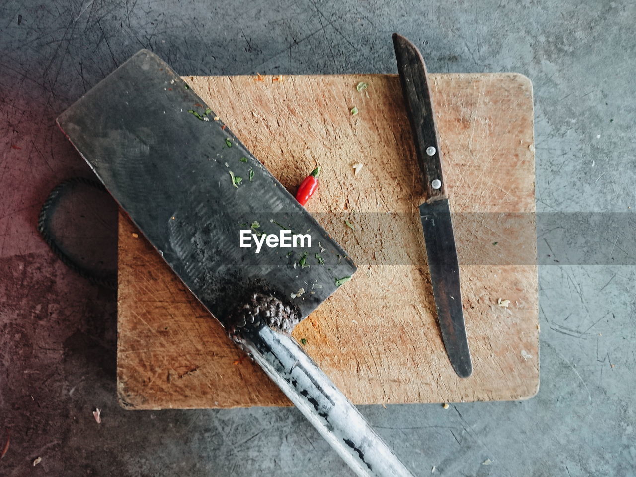 Directly above shot of knife and meat cleaver on cutting board over table