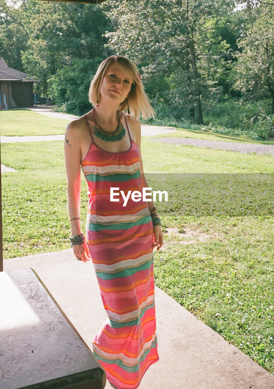Full length portrait of mature woman wearing dress at backyard