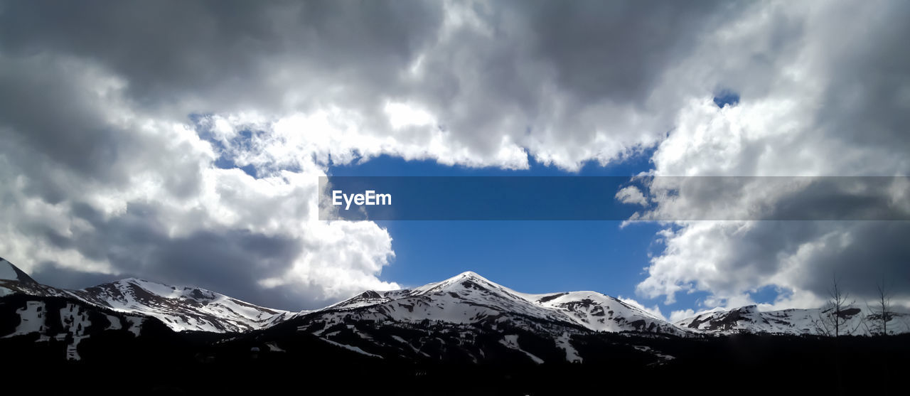 Low angle view of snowcapped mountains against sky