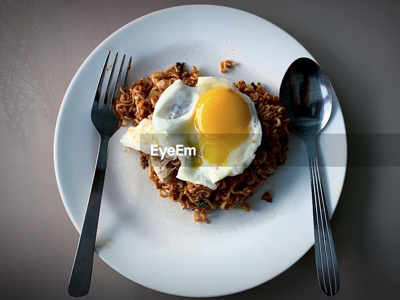 High angle view of fried egg and noodles in plate on table