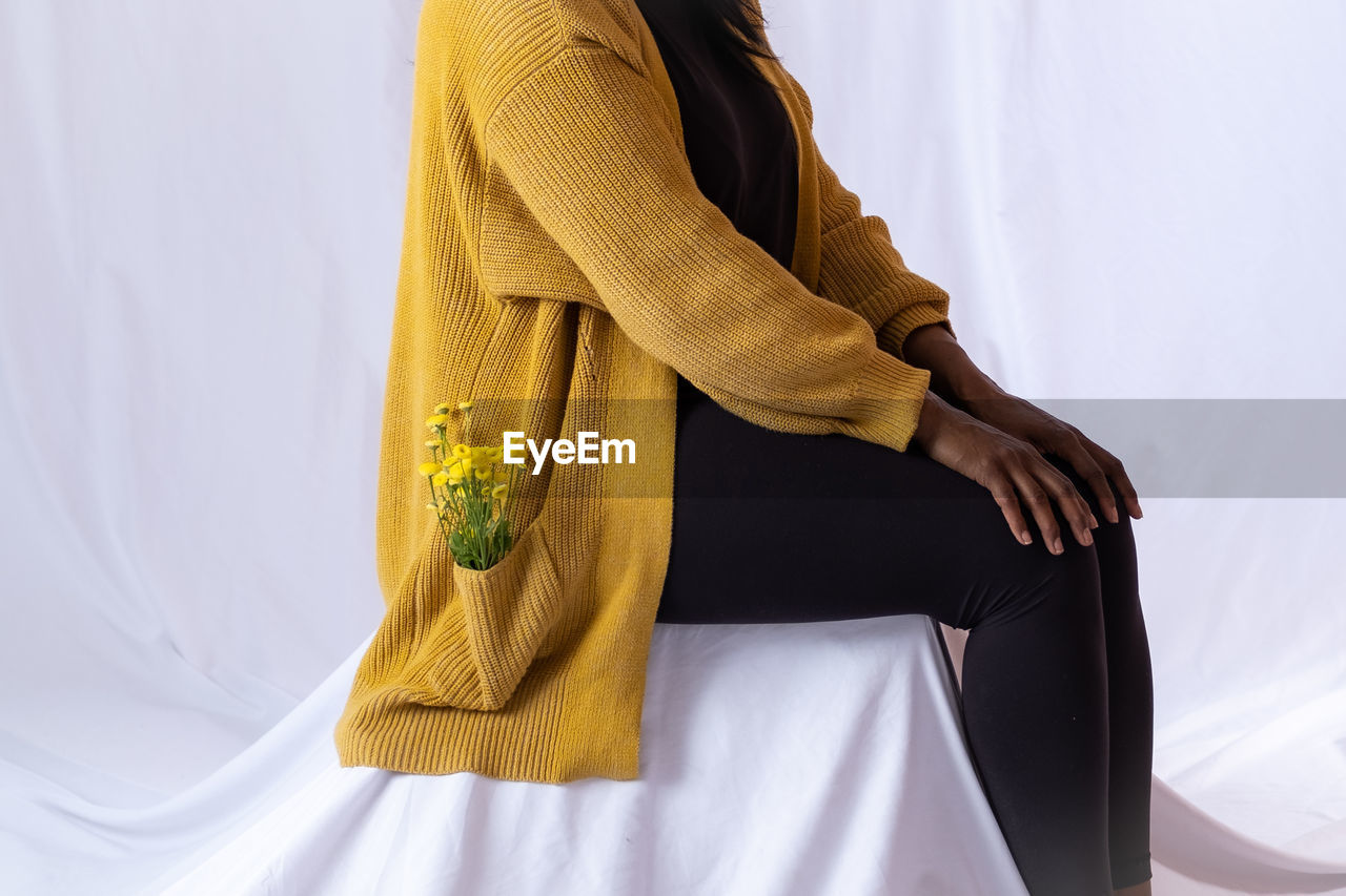 midsection of woman standing against white background