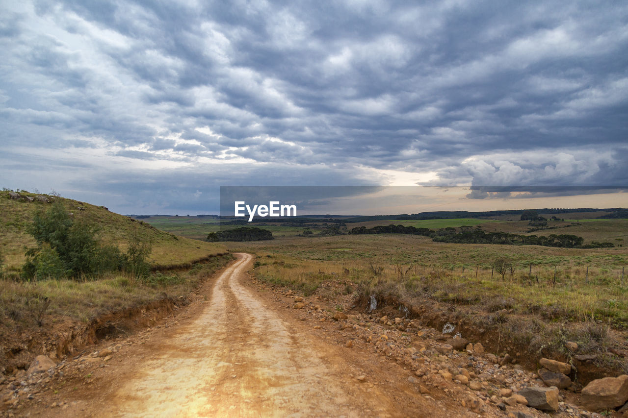 Dirt road along countryside landscape