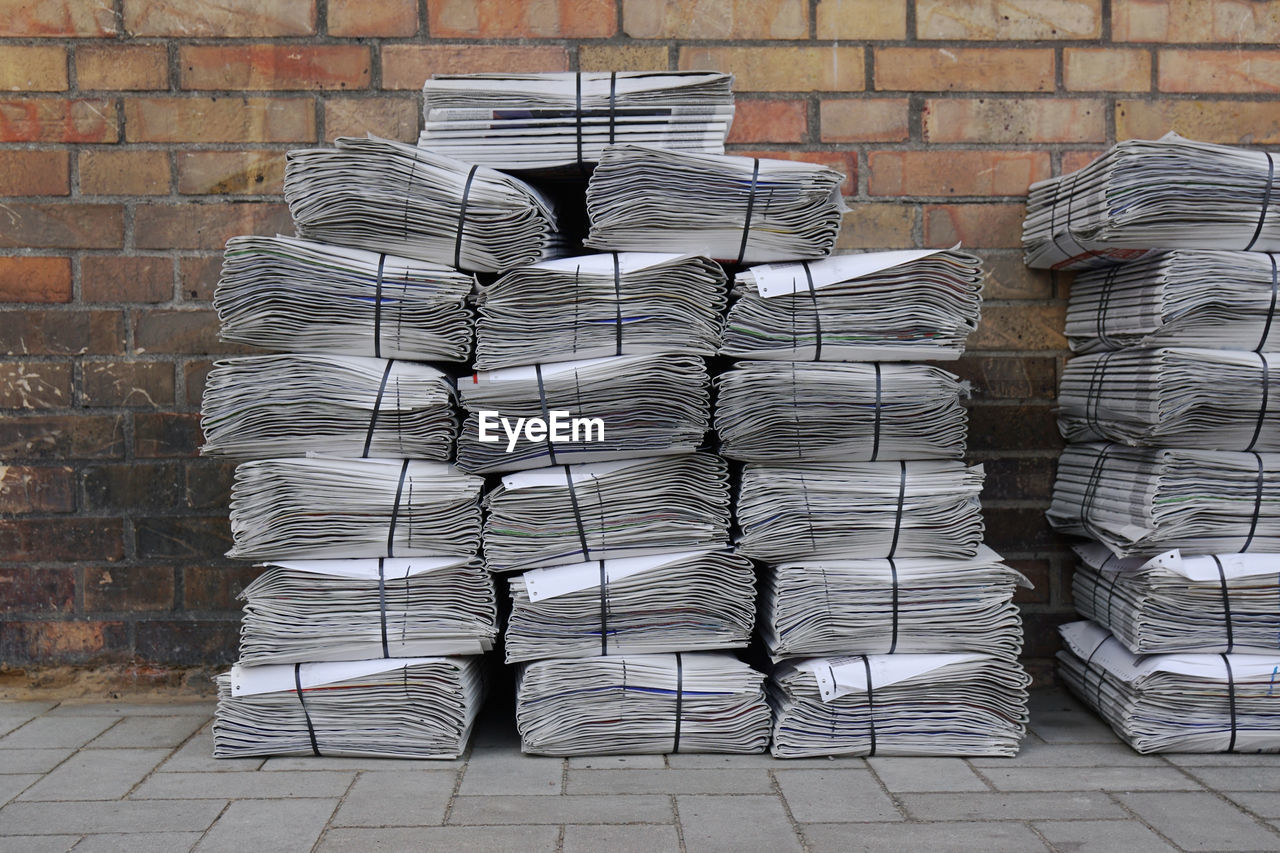 Stack of newspapers on sidewalk