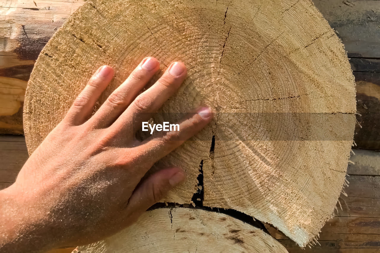 CLOSE-UP OF PERSON HAND ON WOOD