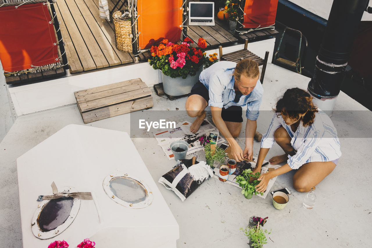 High angle view of couple planting in houseboat