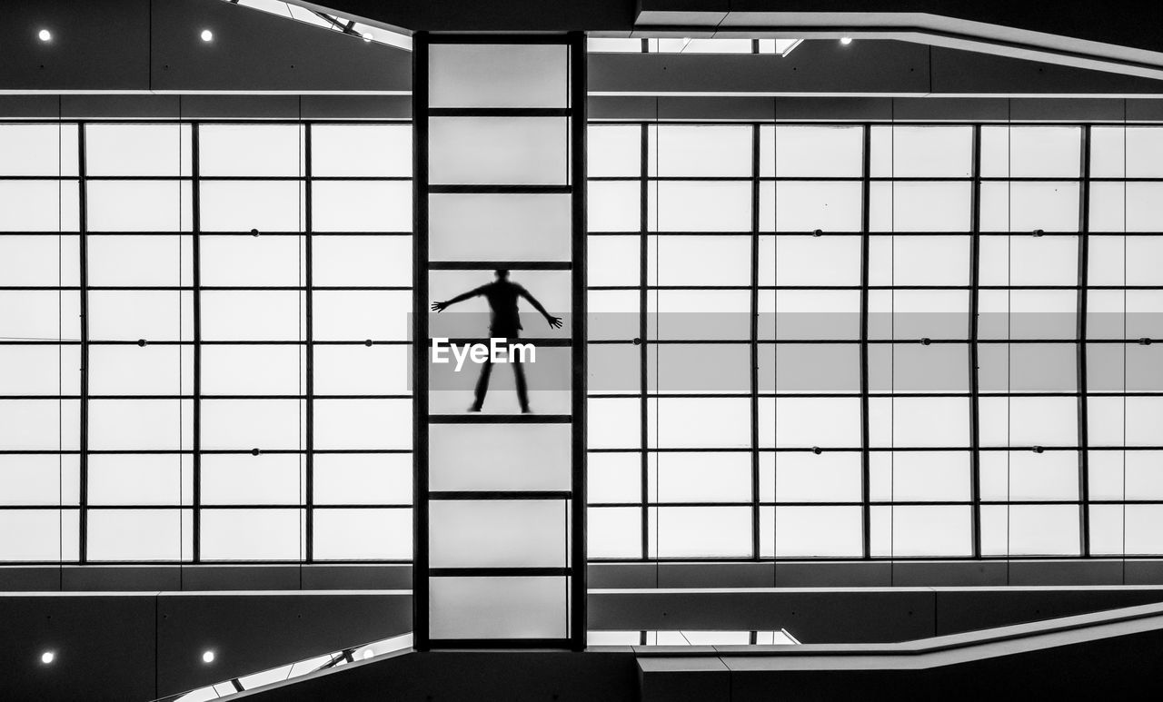 Silhouette man seen through window