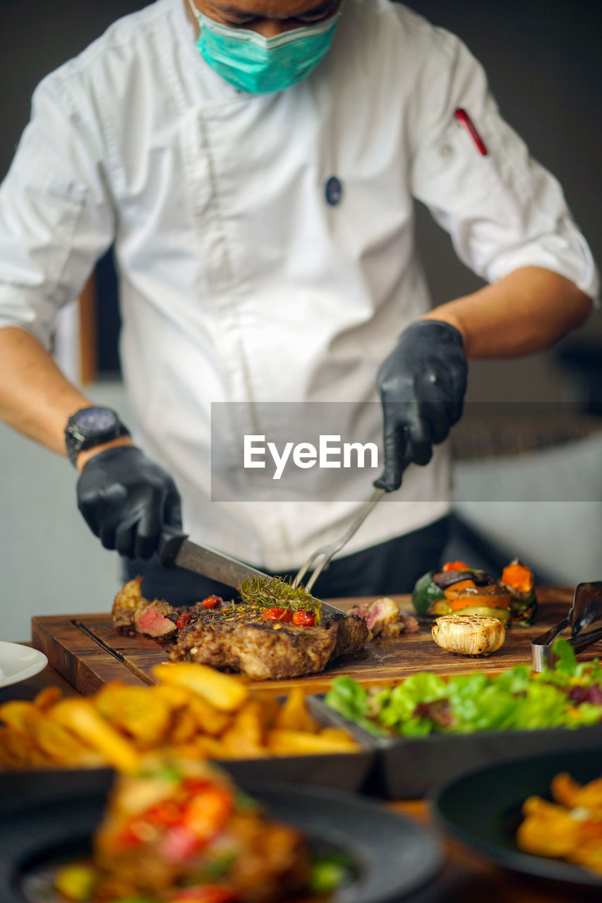 Midsection of man preparing food in kitchen