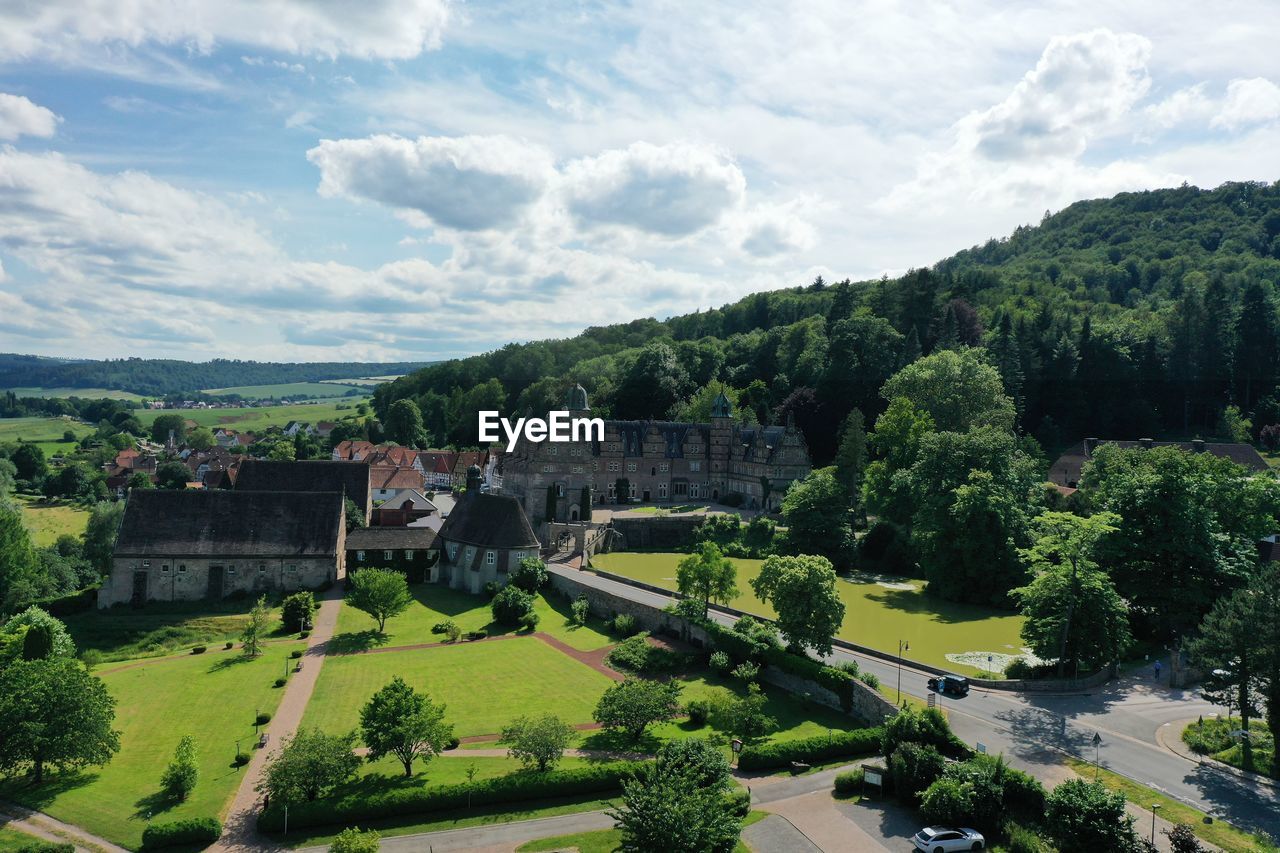 HIGH ANGLE VIEW OF TREES BY BUILDING AGAINST SKY