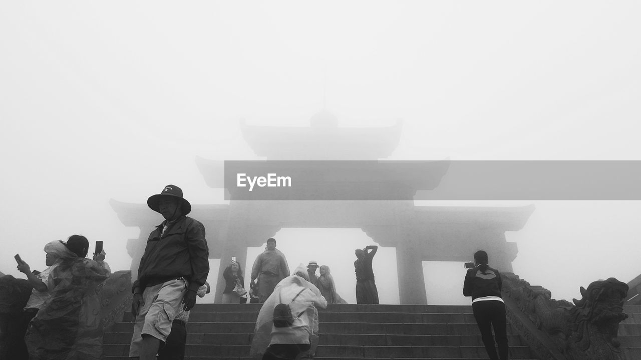 GROUP OF PEOPLE IN TEMPLE AGAINST SKY