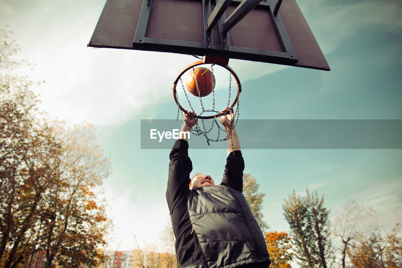 A man shoots the ball into a basketball hoop