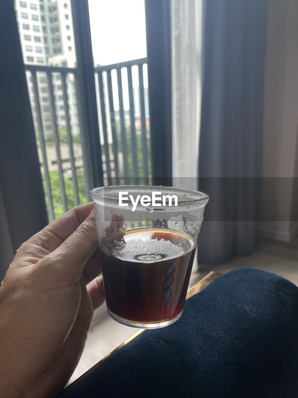 MIDSECTION OF PERSON HOLDING GLASS WINDOW