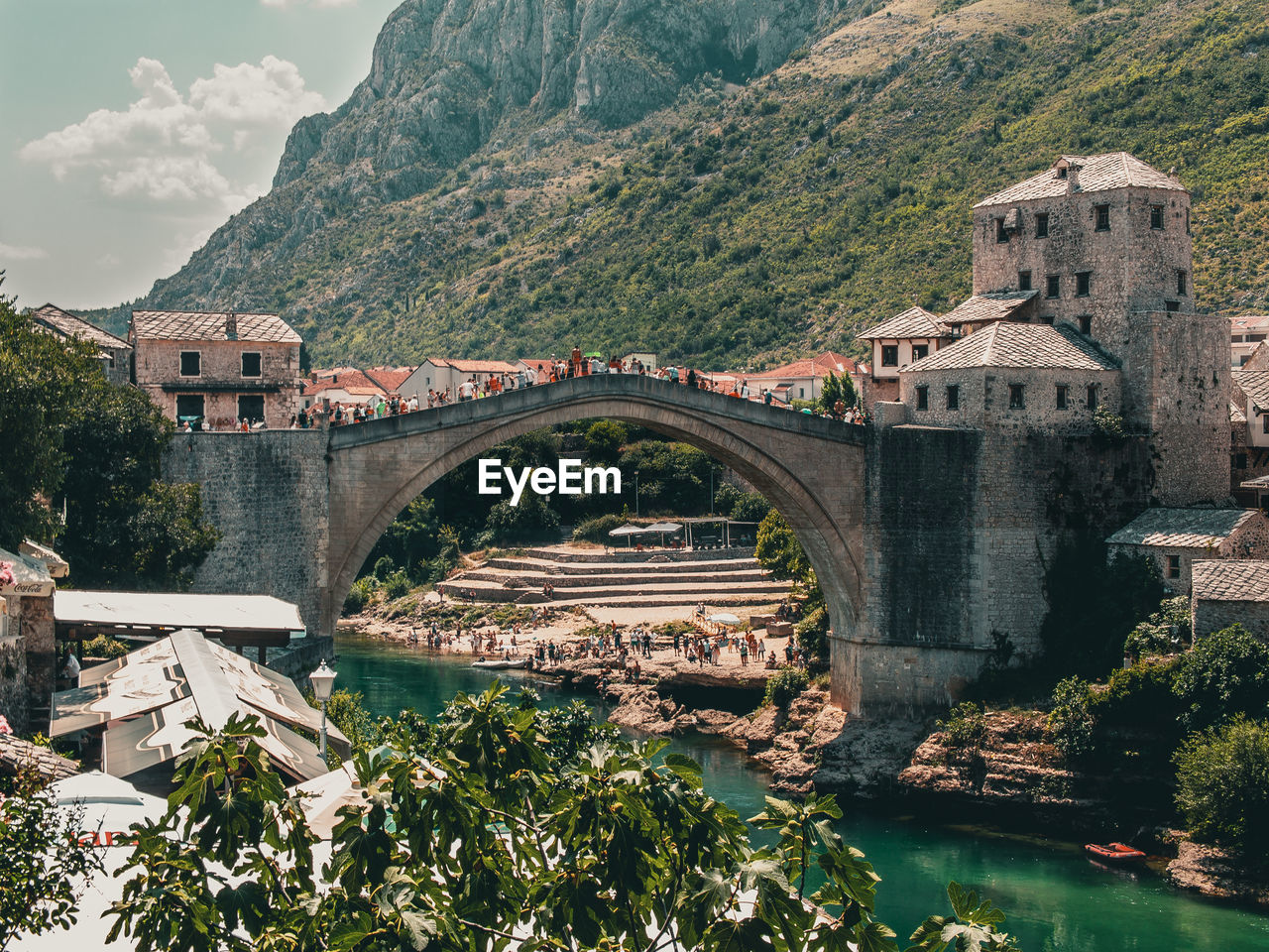 Arch bridge over river amidst buildings