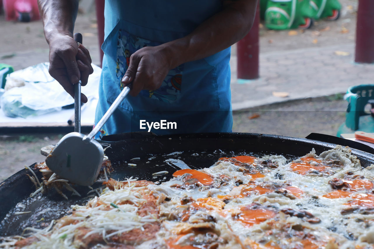 Midsection of man preparing food at market