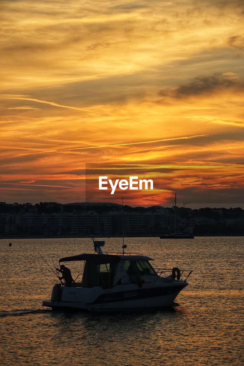 BOAT IN SEA AGAINST SUNSET SKY