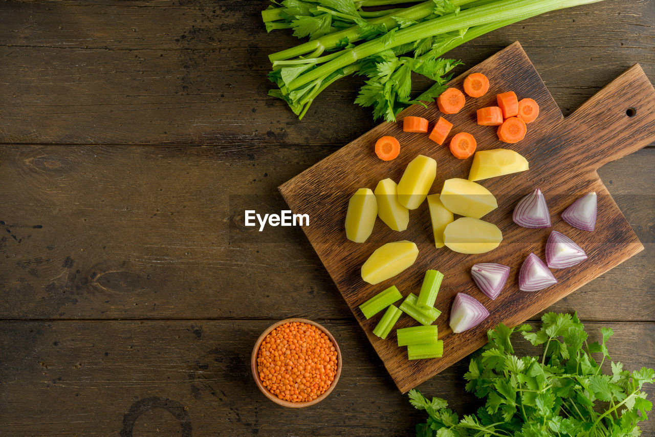 HIGH ANGLE VIEW OF CHOPPED VEGETABLES ON CUTTING BOARD IN KITCHEN