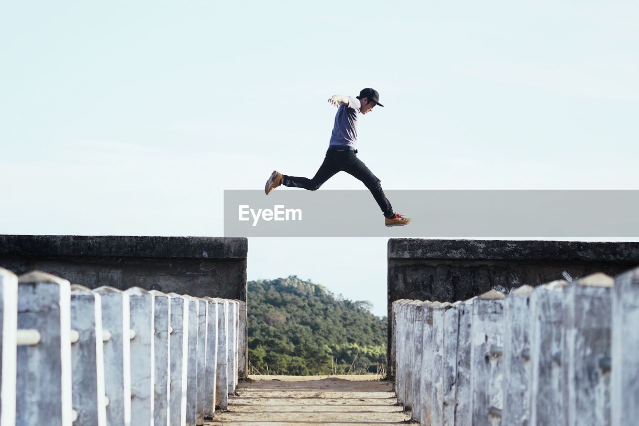 Full length of man jumping against sky