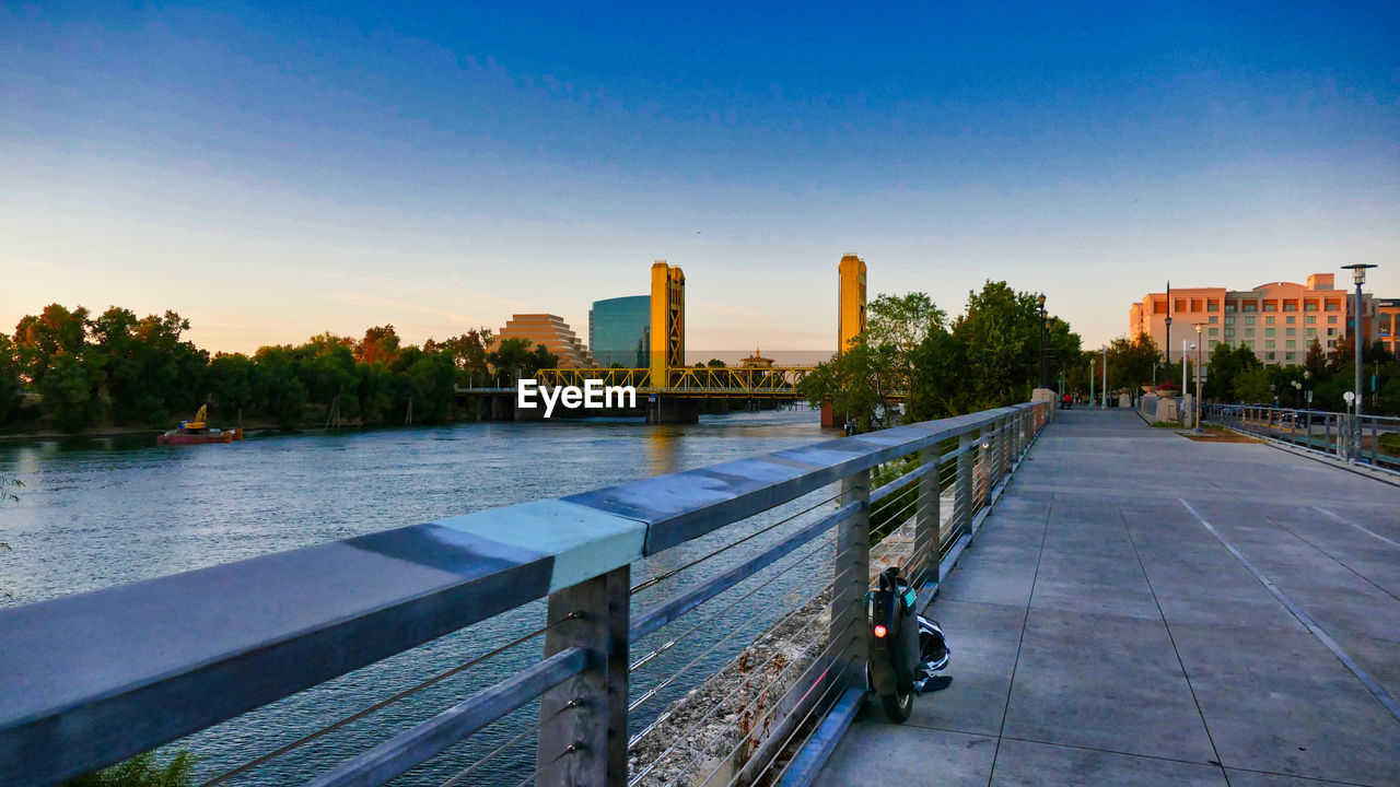 VIEW OF FOOTPATH BY RIVER AGAINST BUILDINGS