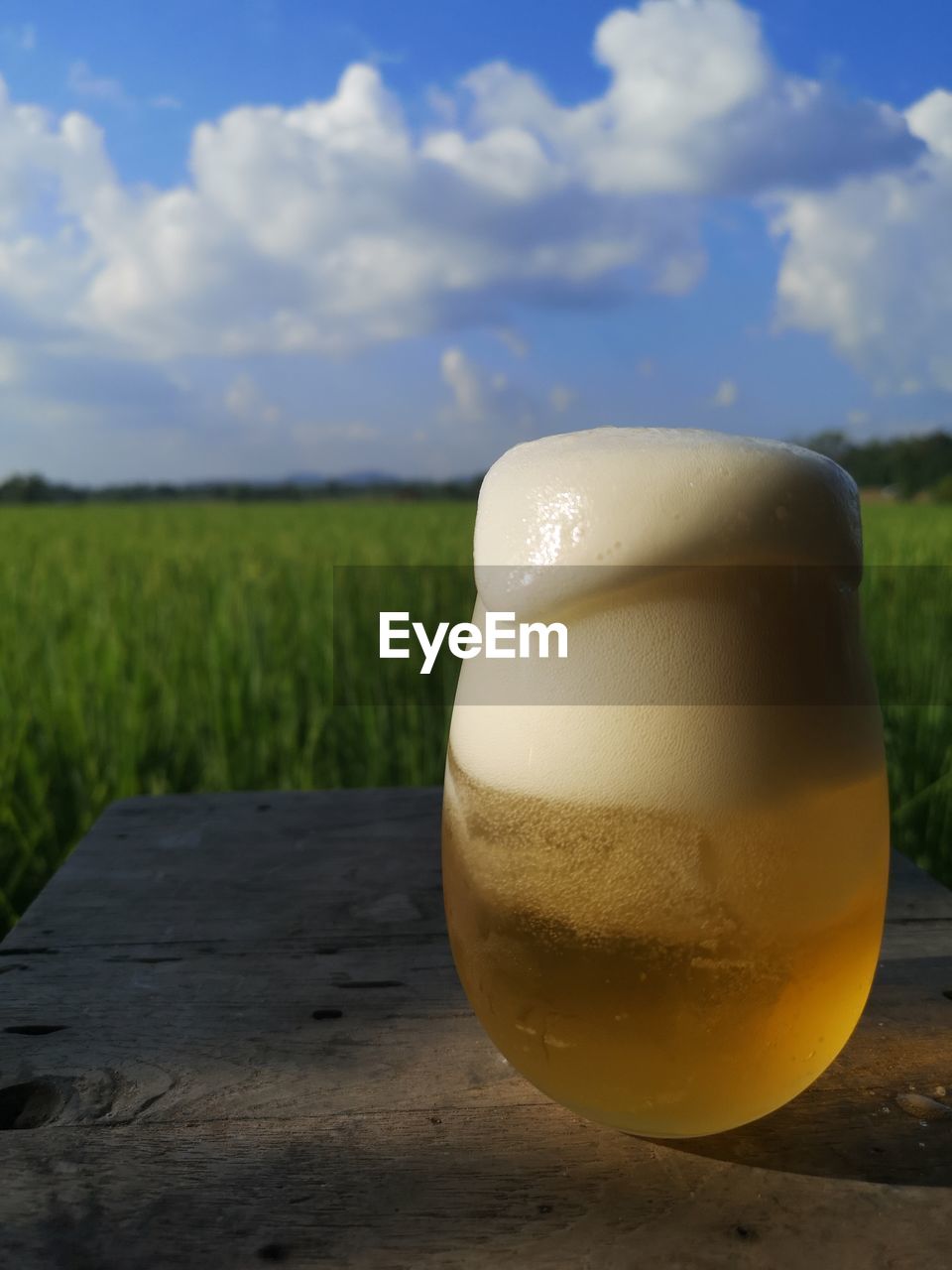 food and drink, cloud, sky, yellow, refreshment, drink, nature, morning, food, land, green, no people, freshness, glass, alcohol, landscape, drinking glass, close-up, beer, plant, focus on foreground, day, outdoors, frothy drink, field, blue, agriculture, light, lighting, beer glass