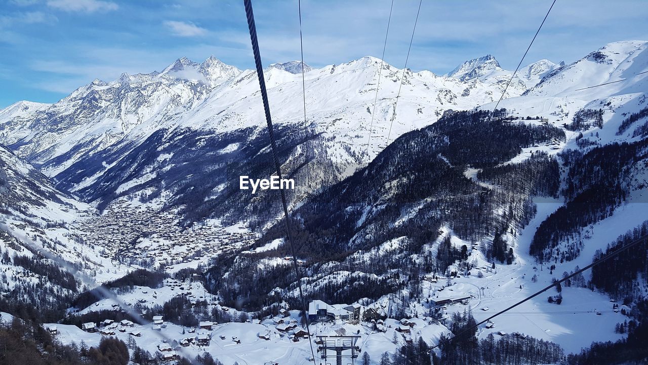 AERIAL VIEW OF SKI LIFT AGAINST SNOWCAPPED MOUNTAINS