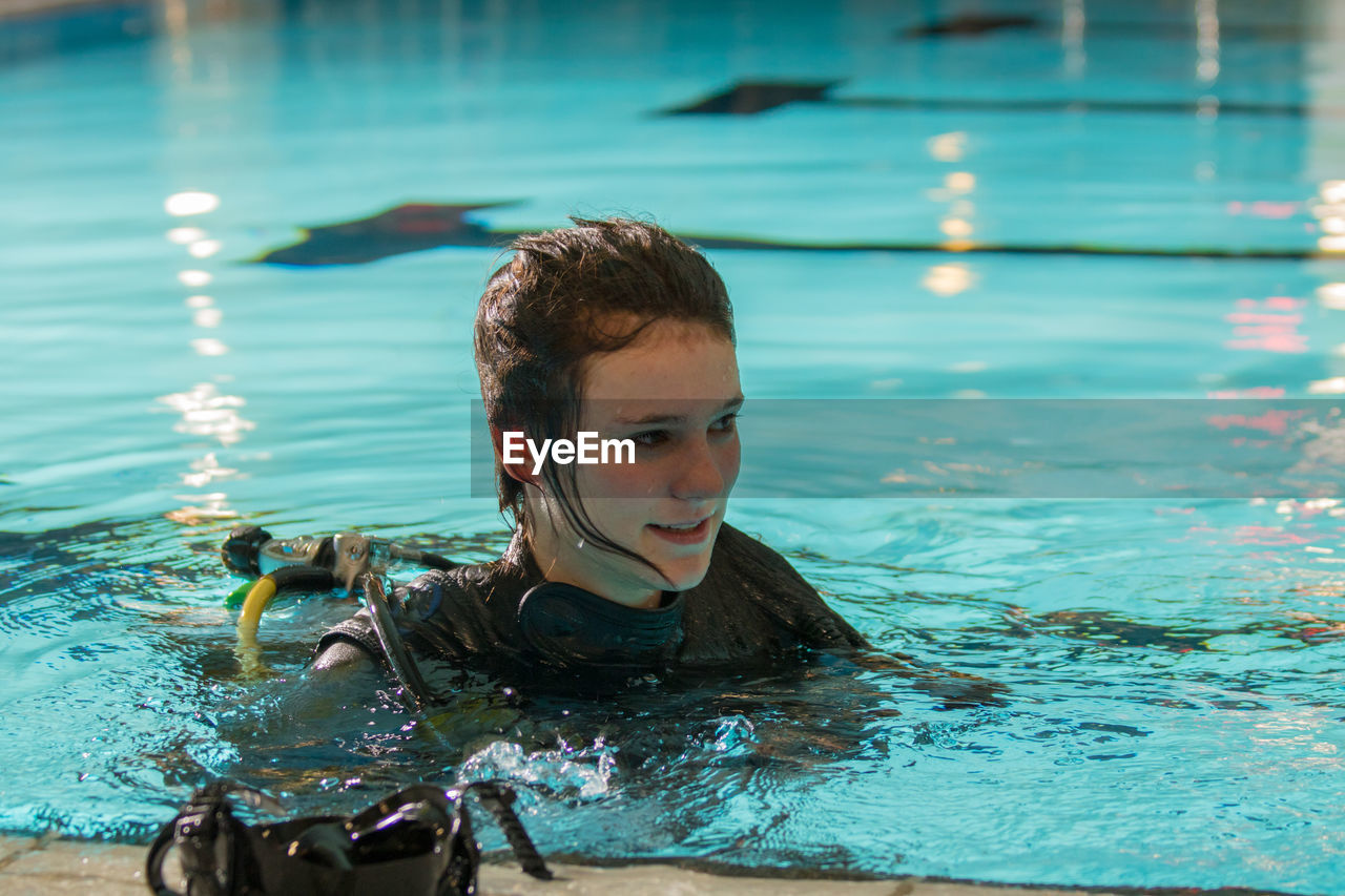 Full length of woman scuba diving in swimming pool